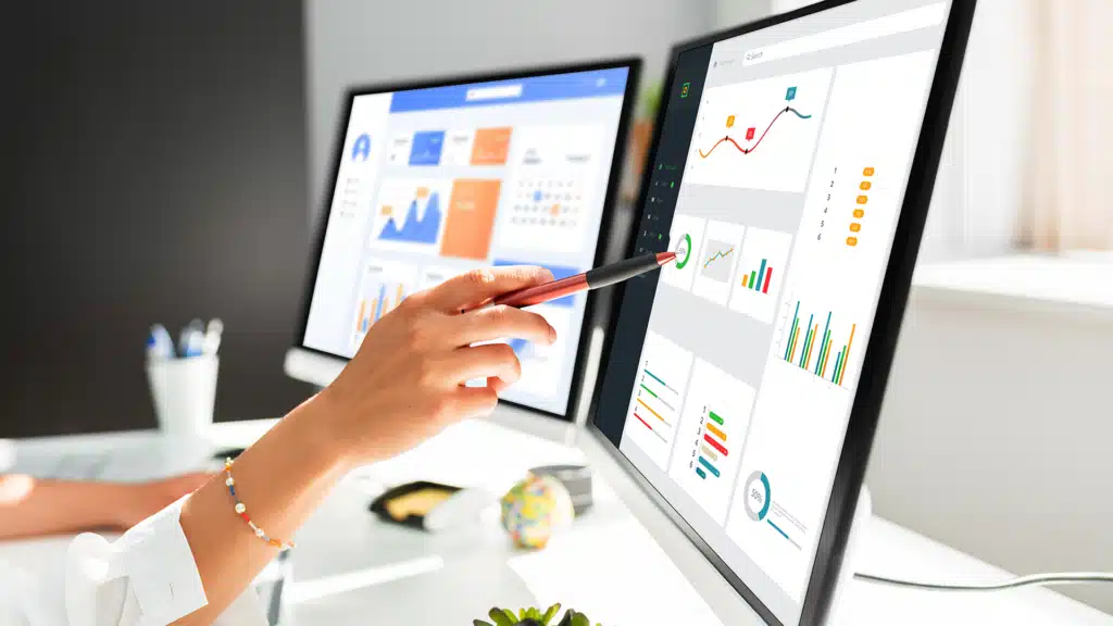 Một Marketer đang làm việc với nhiều màn hình hiển thị dữ liệu, biểu đồ.